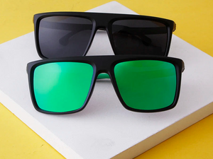 a pair of sunglasses sitting on top of a white surface